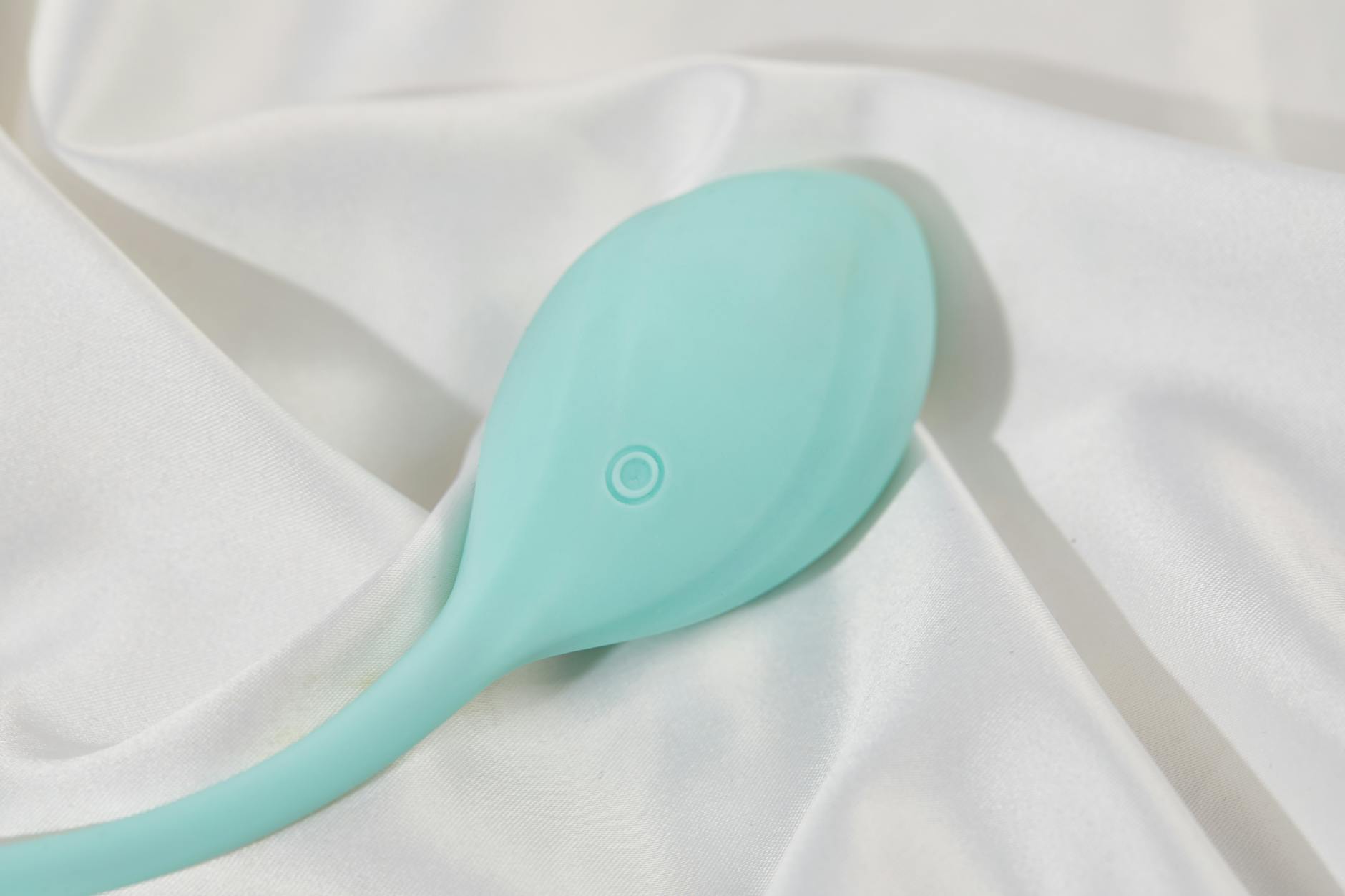 A smooth silicone lemon vibrator on soft white fabric, symbolizing gentle self-care and healing