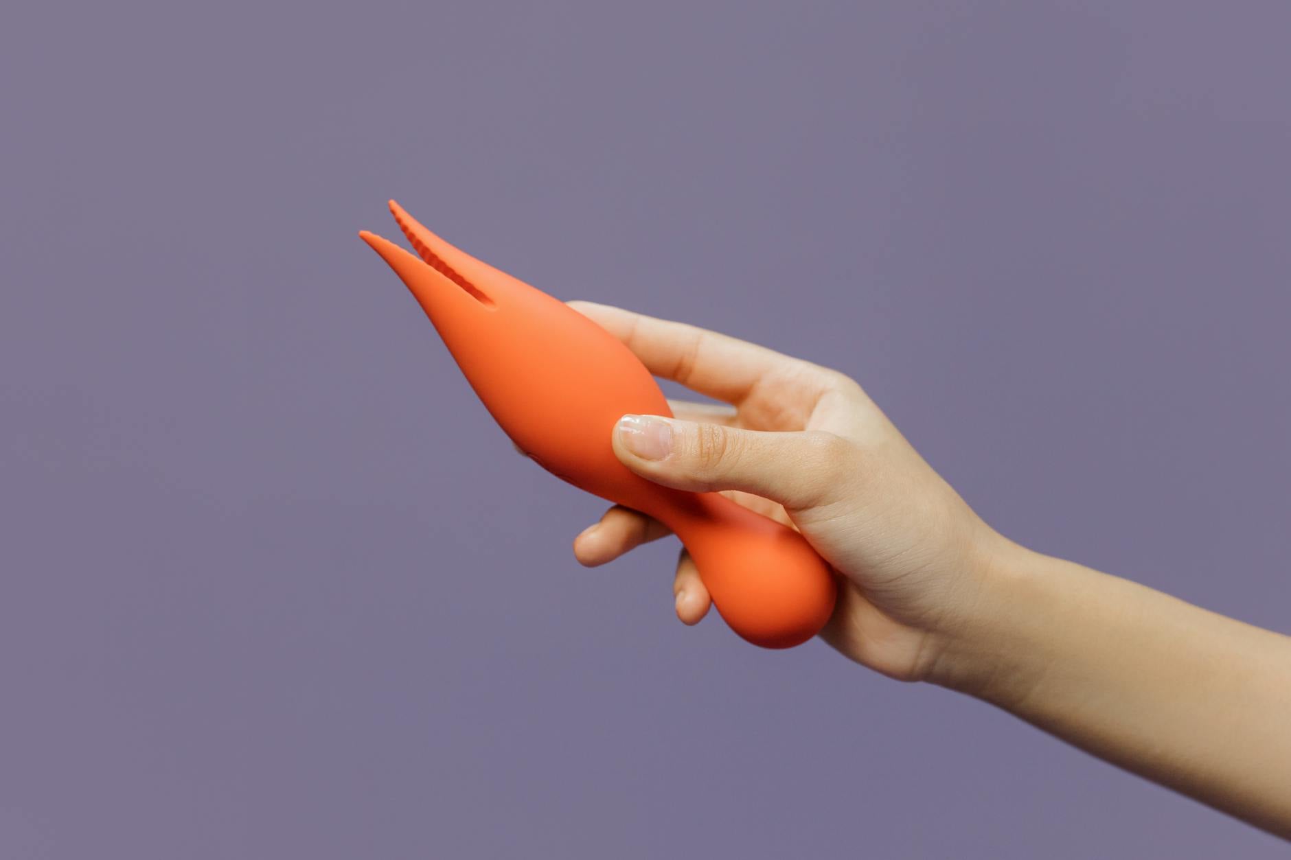 A hand holding a vibrator against a minimalistic purple backdrop, showcasing the ease of returning to pleasure