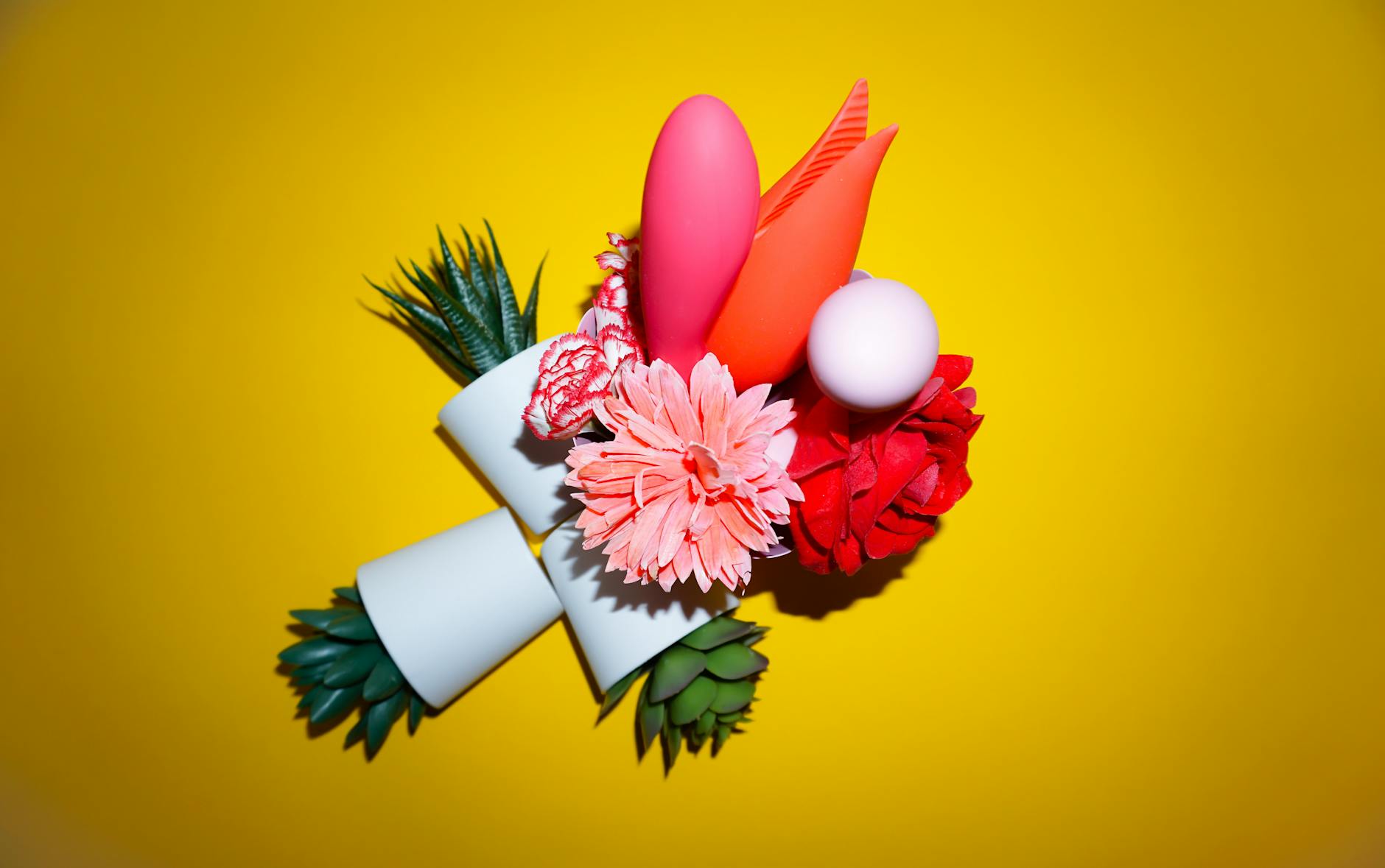 A hand holding a lemon on a soft pink background with more lemons nearby, representing gentle pleasure